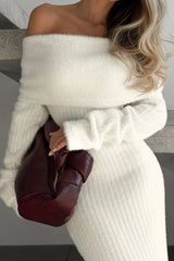 Close-up of a woman's shoulder and chest area wearing a white fuzzy off-the-shoulder maxi dress and holding a burgundy handbag.