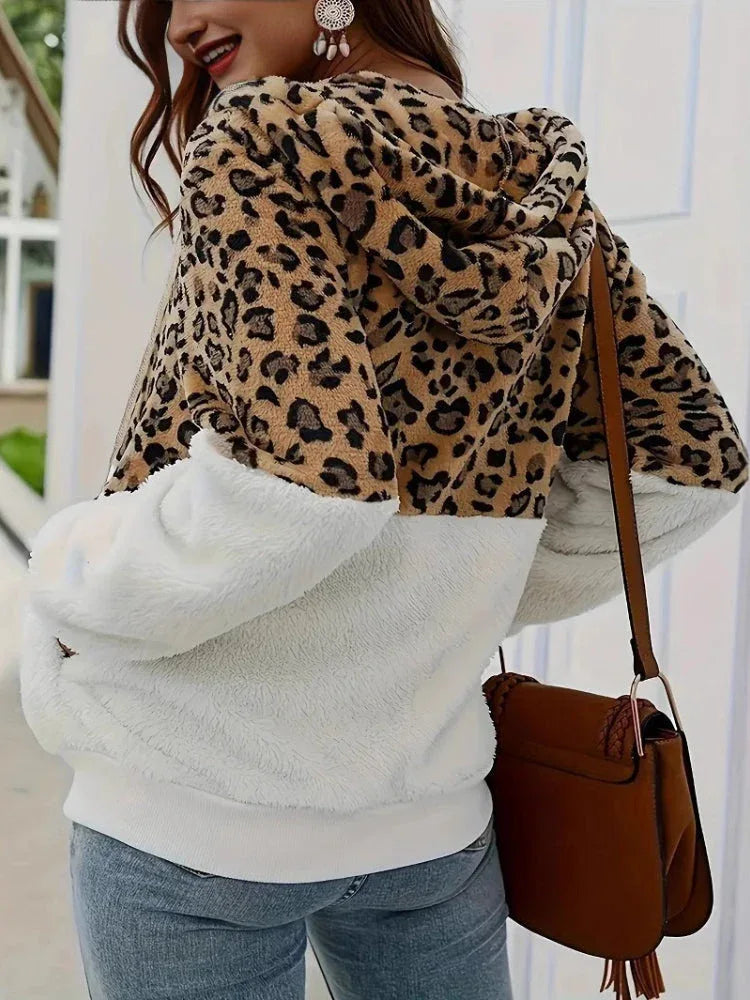 Back view of a woman wearing a leopard print and white sherpa hooded zip-up jacket.