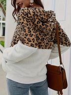 Back view of a woman wearing a leopard print and white sherpa hooded zip-up jacket.