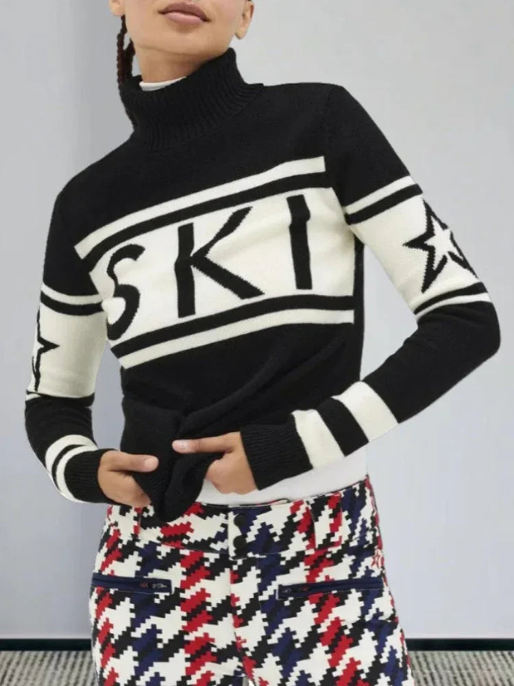 Close-up of a woman wearing a black and white turtleneck ski sweater with "SKI" graphic and stars.