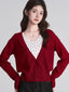 Woman wearing a red V-neck button-down cardigan over a white floral print tank top.