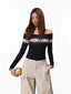 Woman wearing a black off-the-shoulder sweater with a Fair Isle pattern and beige cargo pants, holding a small basketball.