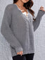Woman wearing a grey knit V-neck sweater with long sleeves