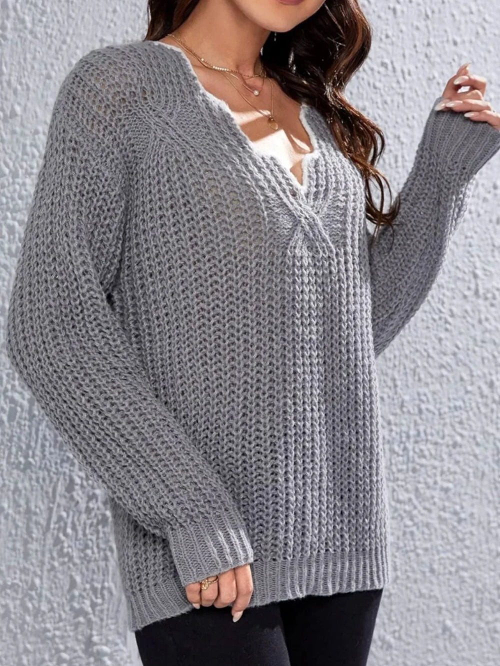 Woman wearing a grey knit V-neck sweater with long sleeves