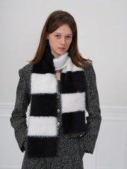 Woman looking at the camera wearing a black and white checkered faux fur scarf