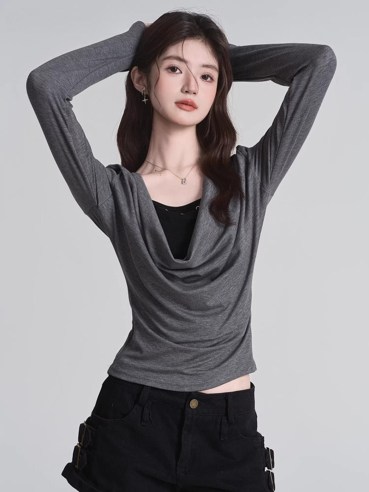 Model wearing a grey long-sleeved top with a draped neckline and a black underlayer.