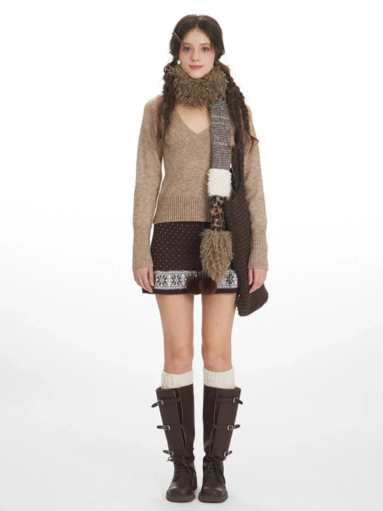 Front view of a woman wearing a beige V-neck sweater, brown patterned mini skirt, white thigh-high socks, and brown boots. Main image