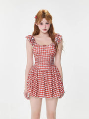 Woman wearing a red and white gingham print dress with ruffled sleeves and a cinched waist.