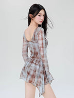 Back view of a woman wearing a plaid mesh mini dress with flared sleeves.
