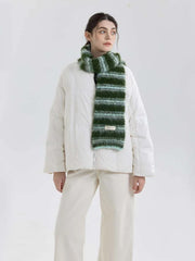 Full body shot of a model in a white puffer jacket and a green and blue striped scarf.