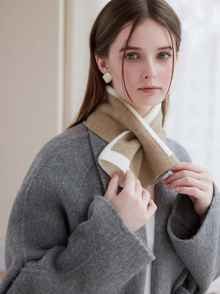 Woman wearing a grey coat and a striped knit scarf