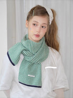 Model wearing a green and white striped knit scarf and white t-shirt.