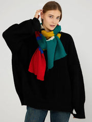 Woman wearing a black sweater and a multicolored striped knit scarf tied around her neck