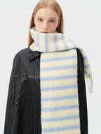 close-up of a model wearing a light yellow and blue striped scarf around her neck