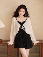 Woman wearing a black one-piece swimsuit with a white sheer cover-up