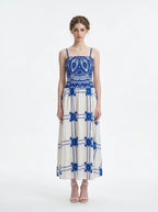 Woman wearing a blue and white crocheted and embroidered maxi dress, front view.