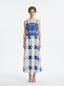 Woman wearing a blue and white crocheted and embroidered maxi dress, front view.