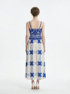 Woman wearing a blue and white crocheted and embroidered maxi dress, back view.