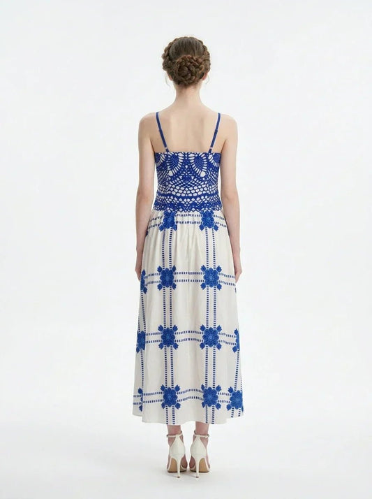 Woman wearing a blue and white crocheted and embroidered maxi dress, back view.