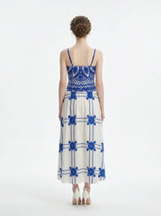 Woman wearing a blue and white crocheted and embroidered maxi dress, back view.