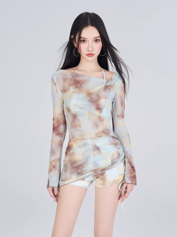 Woman wearing a tie-dye print mesh overlay long sleeve top and matching shorts