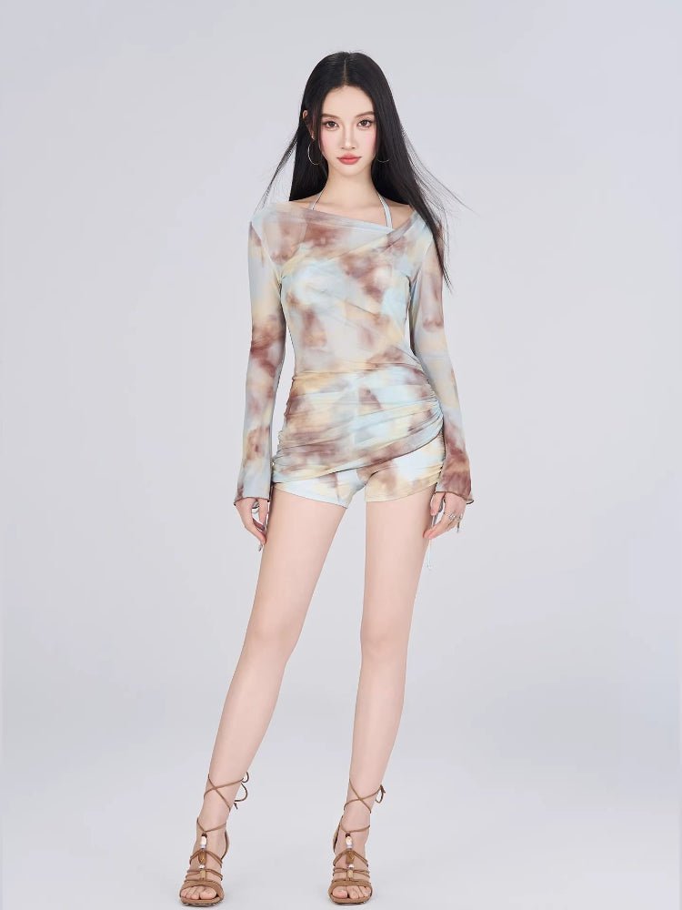 Woman in a tie-dye print mesh overlay top and shorts, standing
