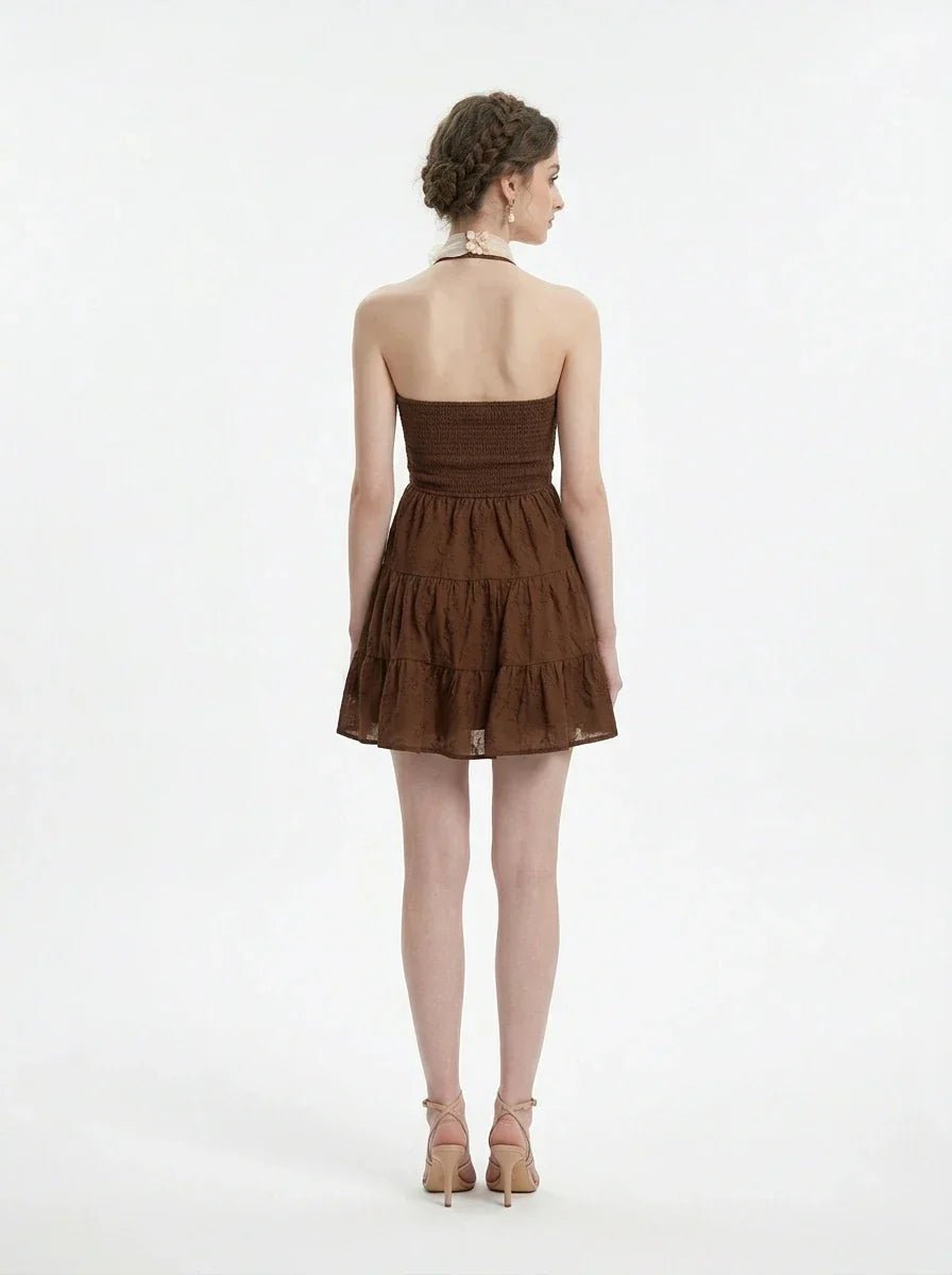 Woman wearing a brown tiered mini halter dress, back view