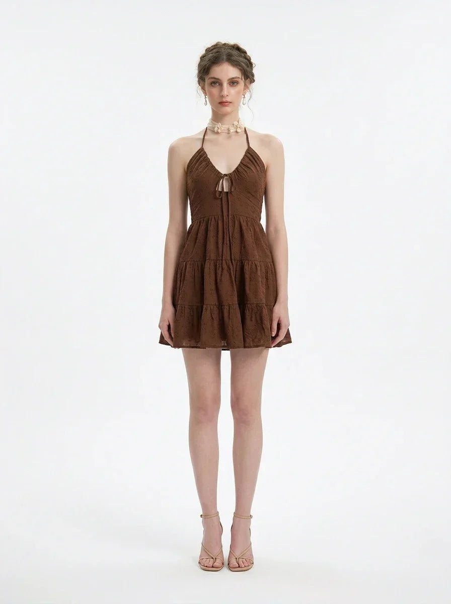Woman wearing a brown tiered mini halter dress, front view