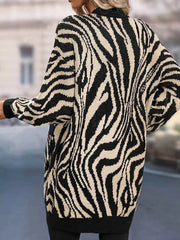 Back view of a woman wearing a black and white zebra print longline knit cardigan.