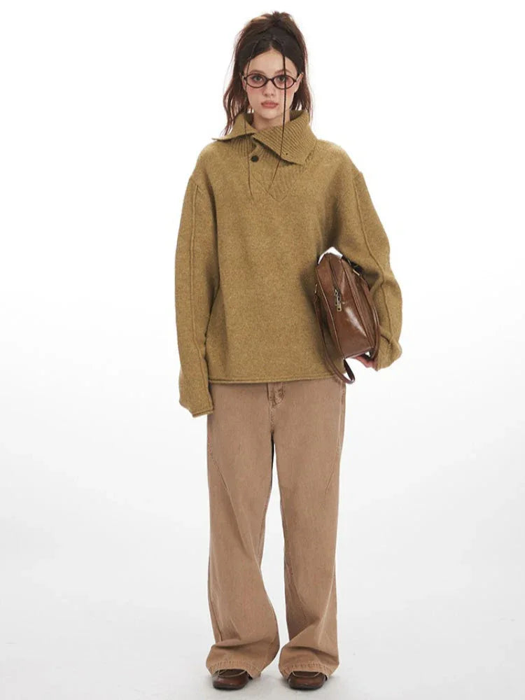 Model wearing a tan oversized knit sweater with wide collar and button detail, paired with tan wide-leg pants and holding a brown crossbody bag, front view. Main image