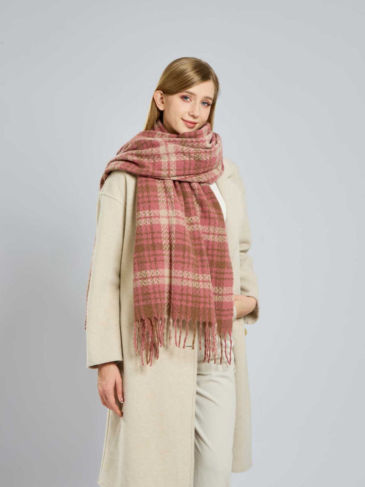 Woman with a hand in her coat pocket, wearing a plaid scarf.