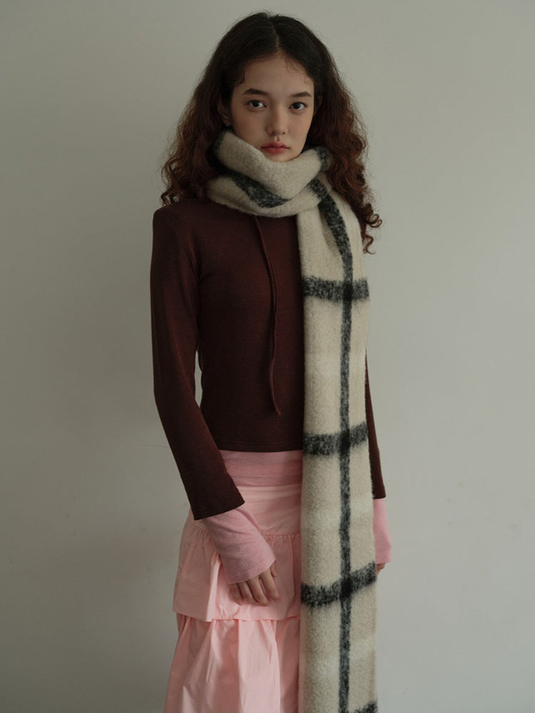 Model wearing a brown long-sleeved top, pink tiered skirt, and a cream and black plaid scarf. Main image