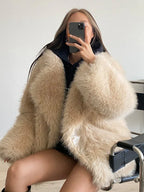 woman wearing a beige faux fur coat and black hoodie