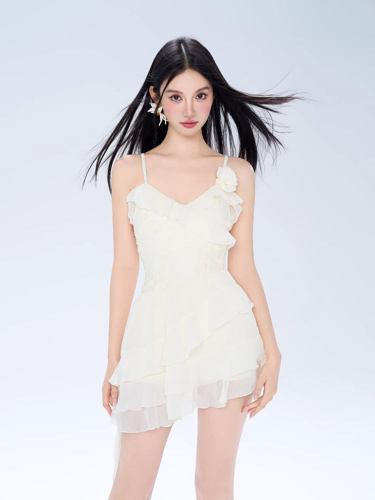 Model wearing a white ruffled mini dress with spaghetti straps and a layered skirt