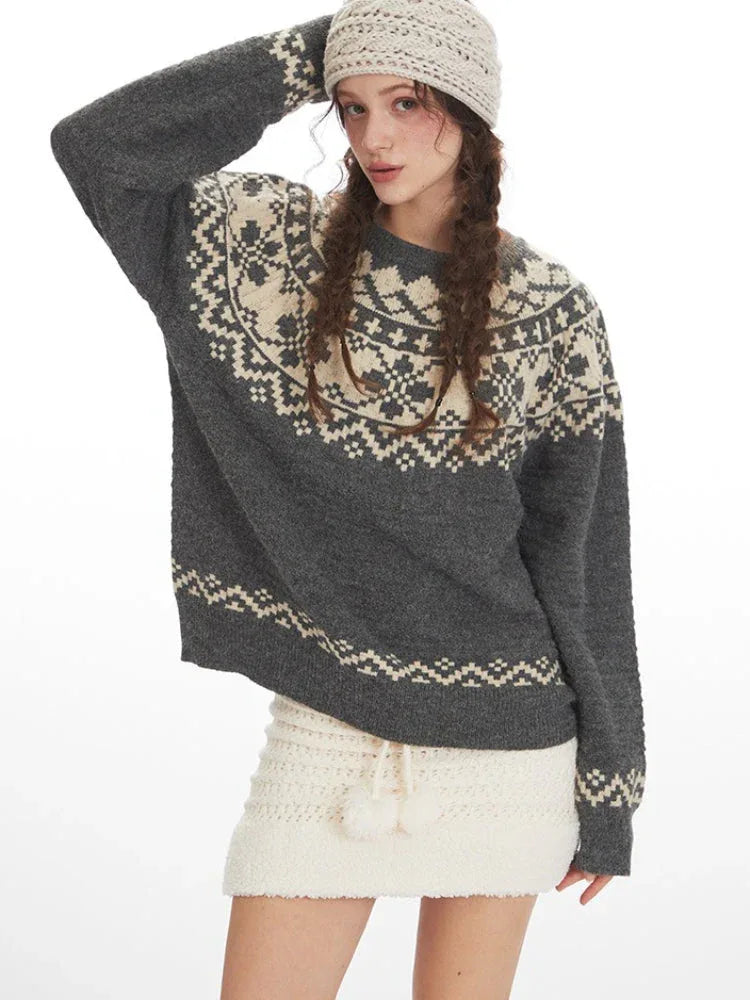 Close-up of a woman wearing a grey and cream Fair Isle knit sweater and a white headband, front view