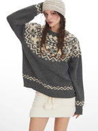 Close-up of a woman wearing a grey and cream Fair Isle knit sweater and a white headband, front view