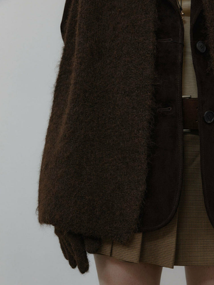 Close-up of the sleeve and lapel of a brown fuzzy jacket with matching gloves