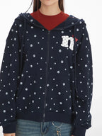 Close-up front view of a navy blue hooded zip-up jacket with a white paw print pattern and a graphic detail on the chest.