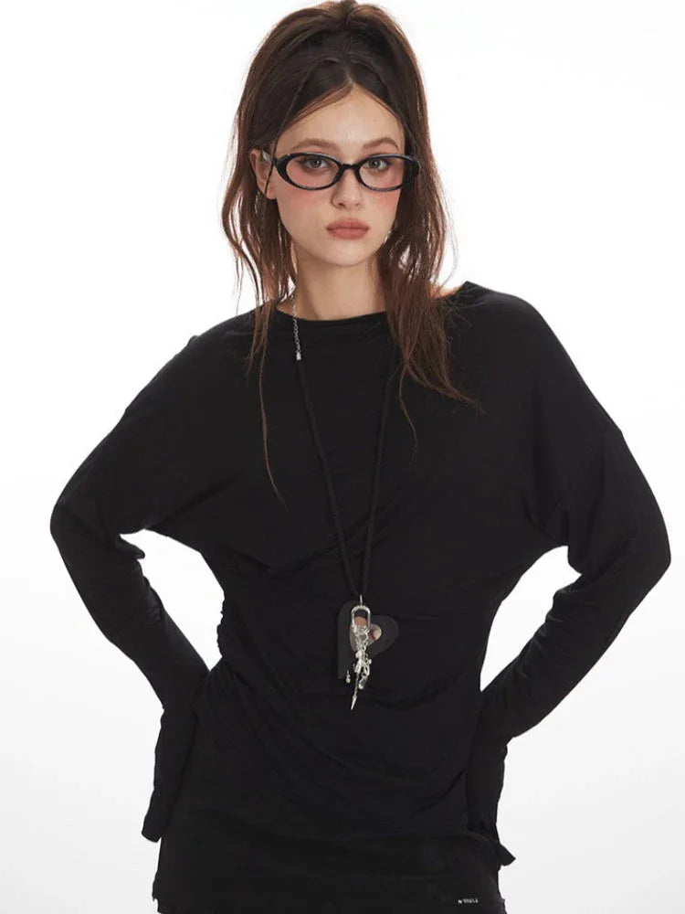 Front view of a woman wearing a black long-sleeve mini dress, star-patterned tights, and glasses.