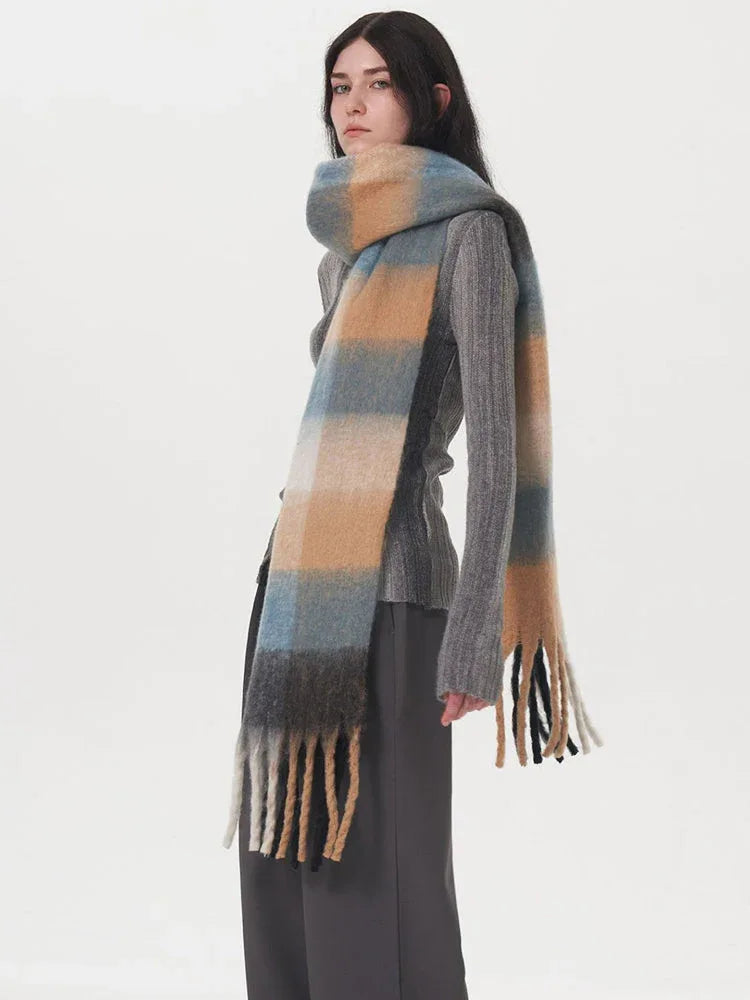 Model wearing a grey sweater and plaid scarf