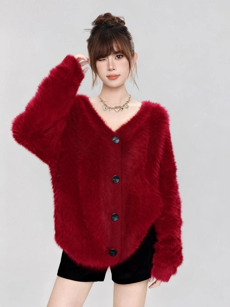 Woman wearing a fuzzy red V-neck button-up cardigan, winking.