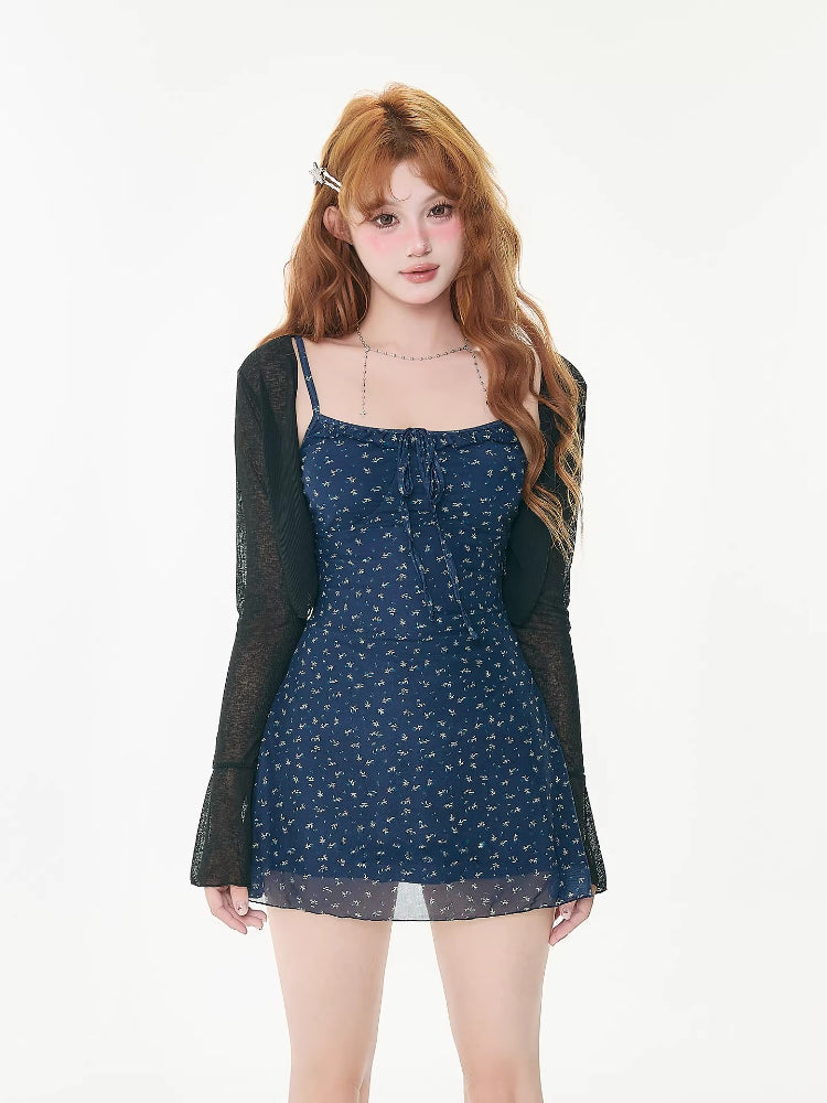 woman wearing a blue floral mini dress with a sheer black cardigan