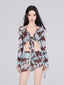 Woman wearing a light blue and brown floral print sheer mesh two-piece set with a tie-front top and a ruched mini skirt.