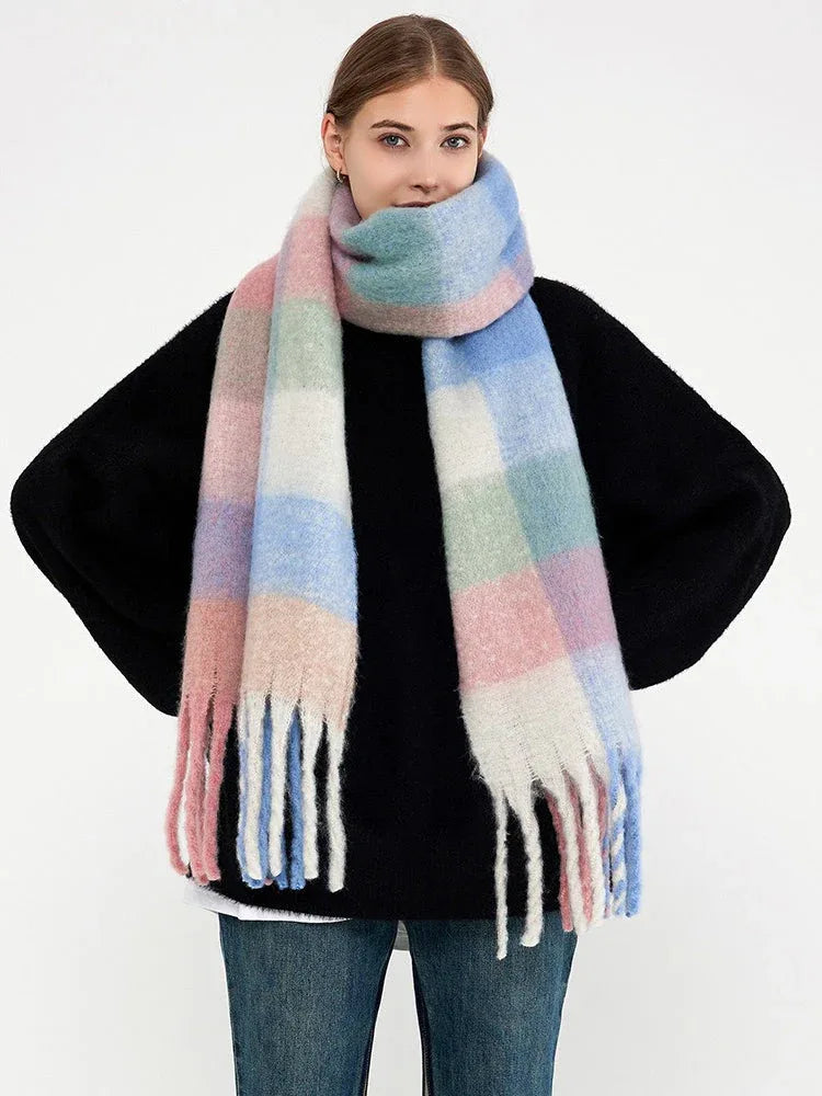 Woman in a black sweater and a pastel plaid scarf draped around her neck.