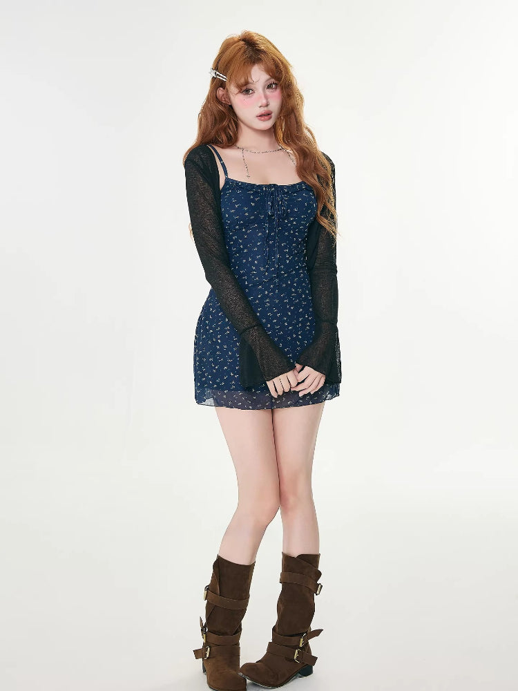 full body shot of a woman in a blue floral mini dress, black cardigan, and brown boots
