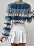 Back view of a woman wearing a blue and white striped crochet knit cropped sweater with bell sleeves, paired with a white pleated mini skirt.