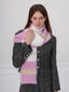 Woman adjusting a pink, white, and beige striped fuzzy scarf.