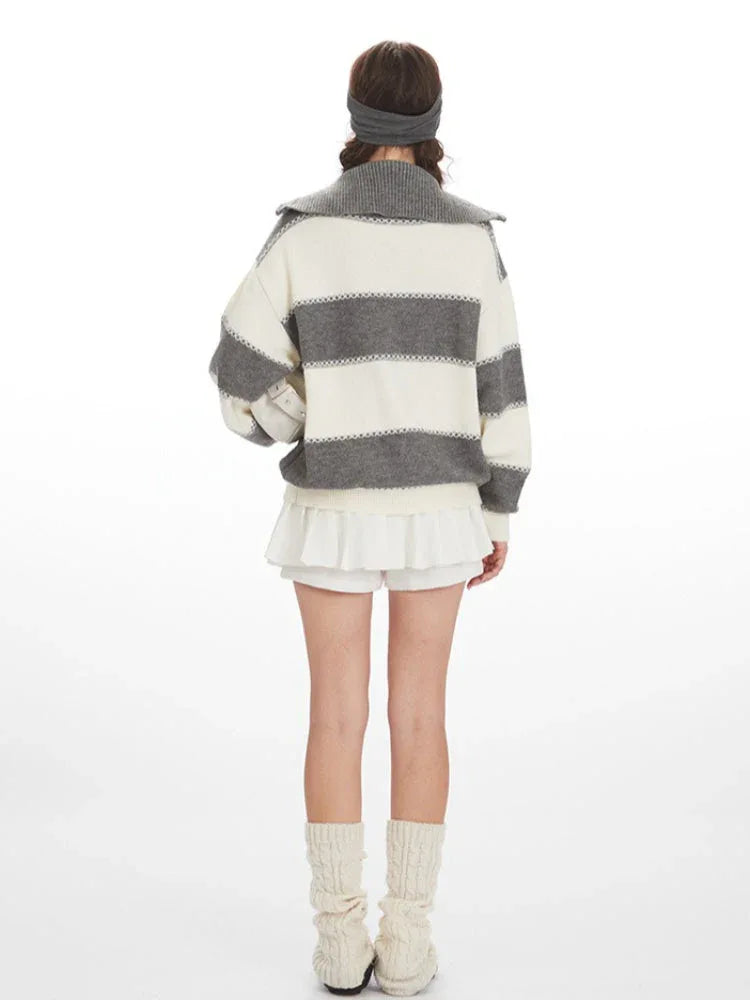 Model wearing a striped knit sweater with a white pleated skirt and cream leg warmers, back view