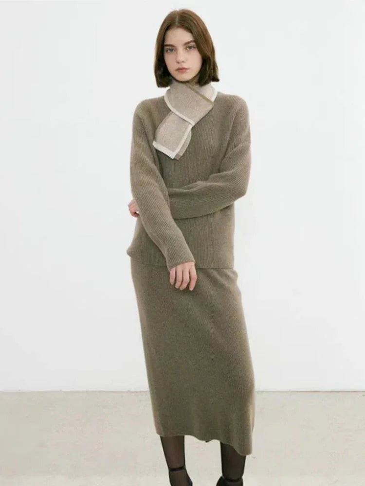 Full body shot of a woman in a taupe knit sweater and skirt set with a scarf