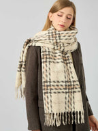 Close-up of a woman wearing a cream, brown, and grey plaid scarf